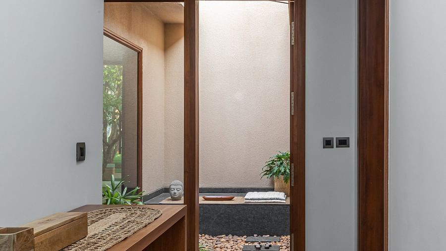Narrow hallway with wooden shelves, doorway at the end, interior architecture - Shreyas Retreat