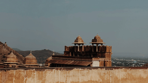 A low-angle shot from inside Amer Fort, under the bright blue sky.
