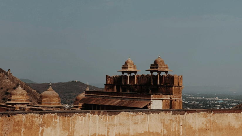 A low-angle shot from inside Amer Fort, under the bright blue sky.