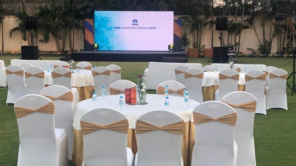 Round table banquet setup with white and gold chairs under natural lighting at Ilara Hotels & Spa, OMR, Chennai