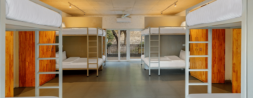 Dorm room with bunk beds and luggage storage.