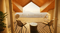 Room with balcony at Pride Premier Darjeeling featuring two chairs and a centre table facing towards the mountain view.