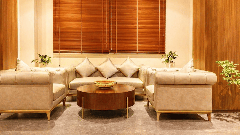 Sitting area of Pride Premier Darjeeling featuring sofa sets and centre table with few plants around.