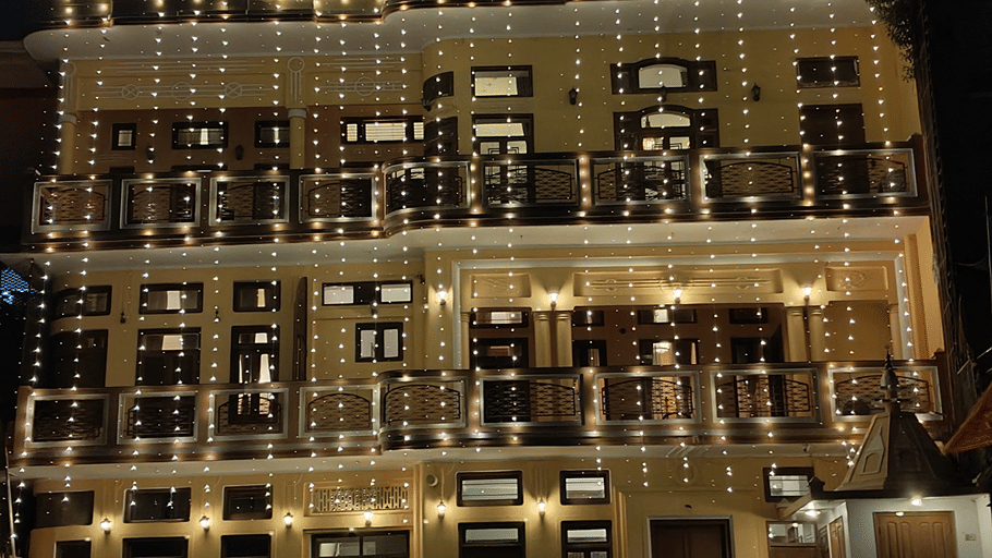 An illuminated facade with mutliple windows and doors. | Hotel Devnadi, Haridwar 