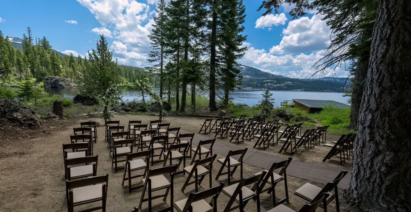 Lakefront outdoor event seating under trees at Kit Carson Lodge.