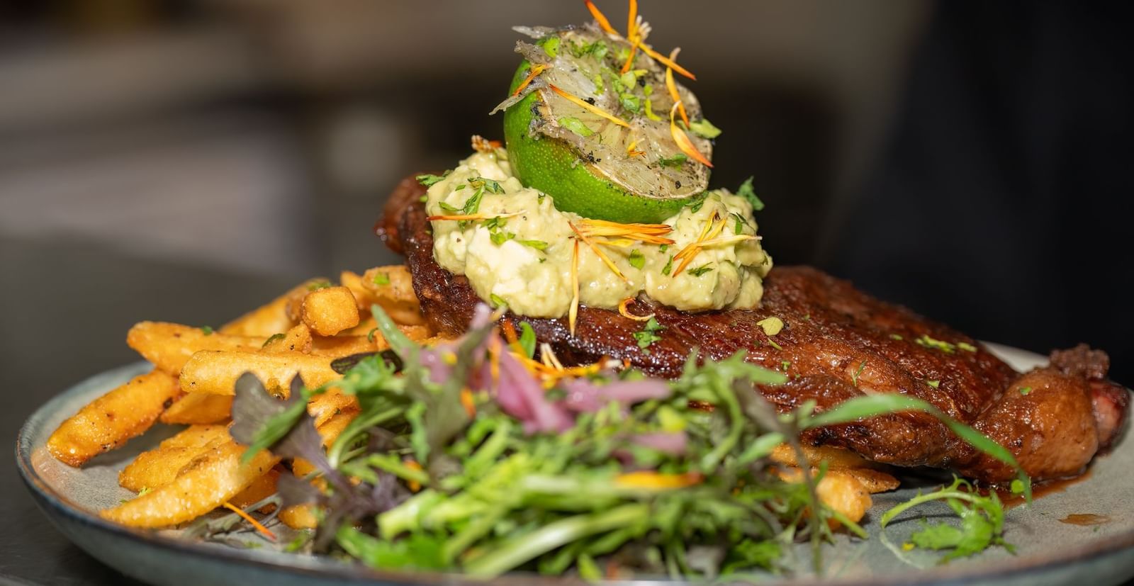 Gourmet dish with steak, vegetables, and mashed potatoes topped with herbs served at Narrow Gauge Inn.