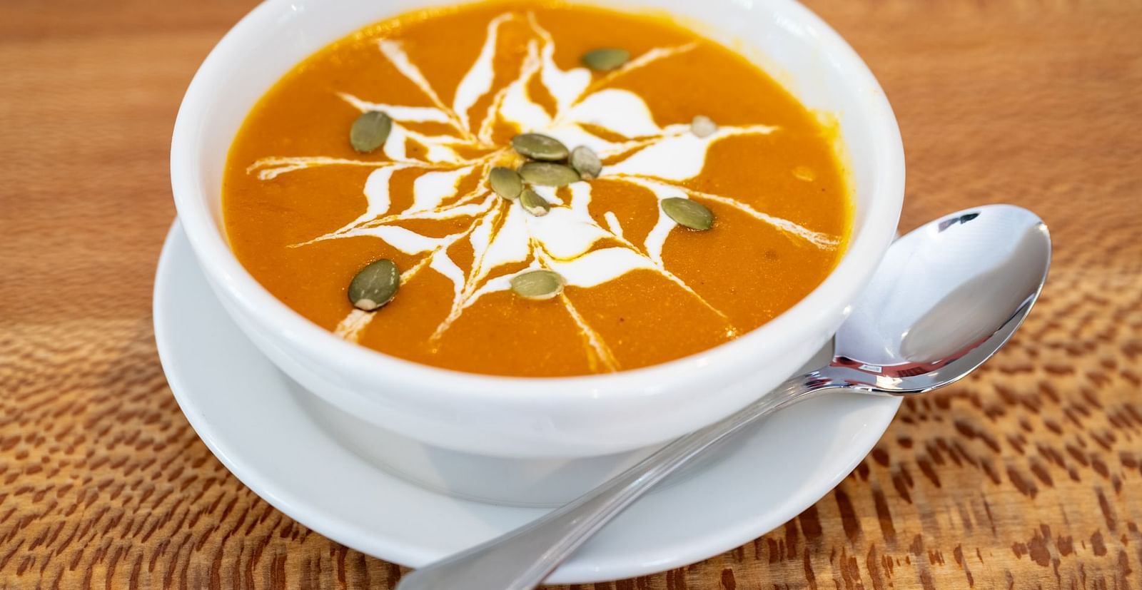Bowl of creamy tomato soup garnished with herbs and cream at The Groveland Hotel.