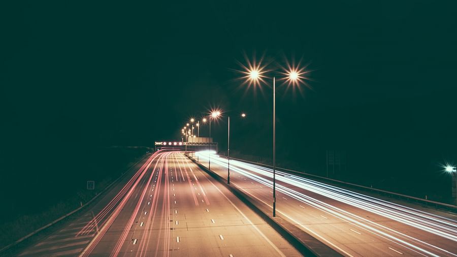 a highway lit up by streetlights in the night