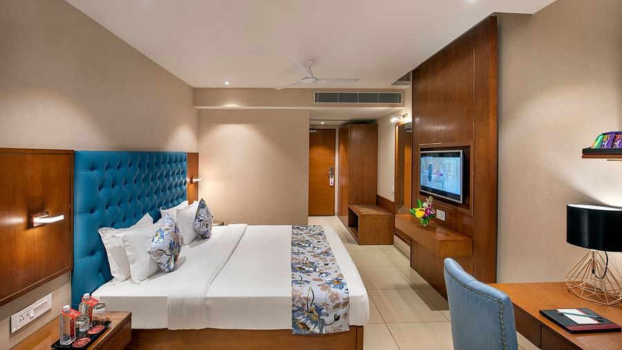 A hotel room with a double bed, desk, and television, showing a comfortable interior - SK Lords Inn Ahmedabad