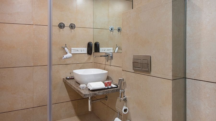 A compact and functional hotel bathroom with a toilet and sink - SK Lords Inn Ahmedabad