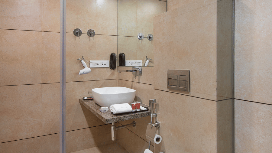 A compact and functional hotel bathroom with a toilet and sink - SK Lords Inn Ahmedabad