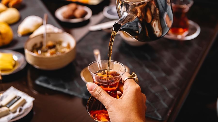 man pours teafrom tea-pot into armudu glass