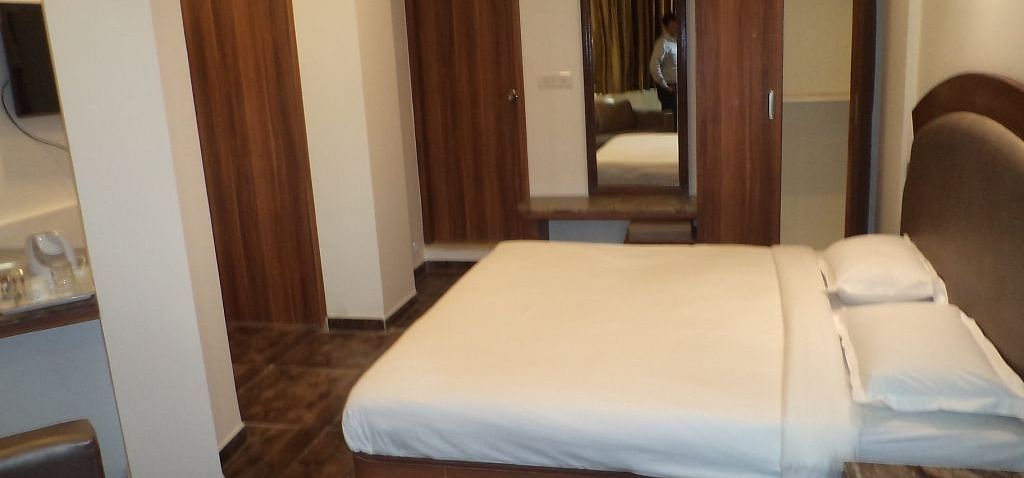 Room with double bed, wardrobe, and full-length mirror