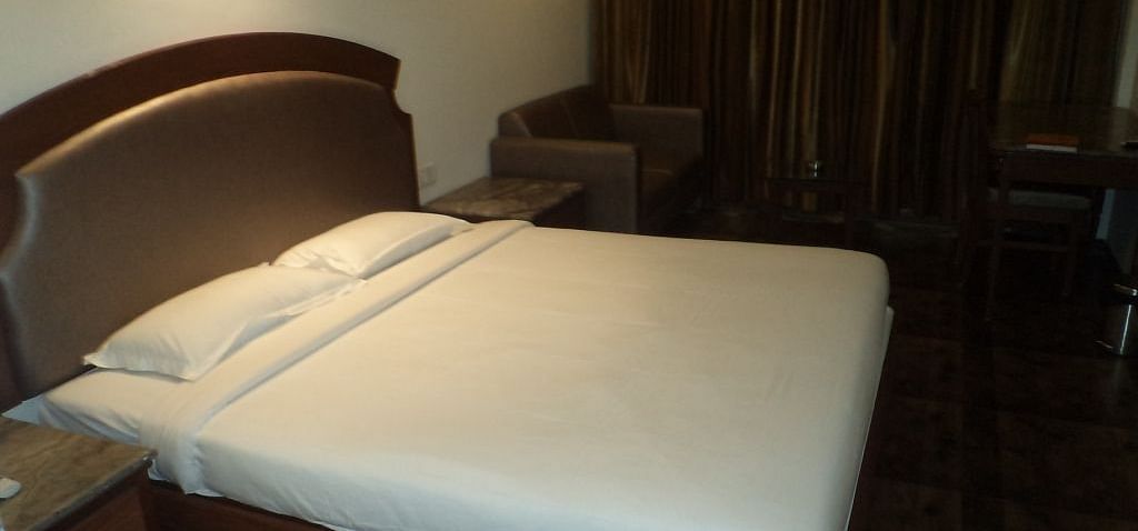 Cozy hotel room with a double bed and dark curtains
