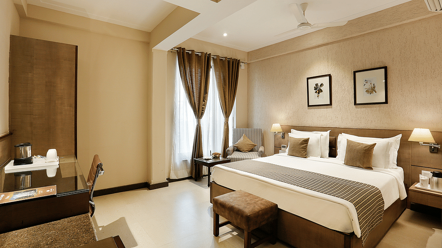 an image of suite at The Manor in Bareilly, featuring a plush bed and a stylish tea/coffee maker