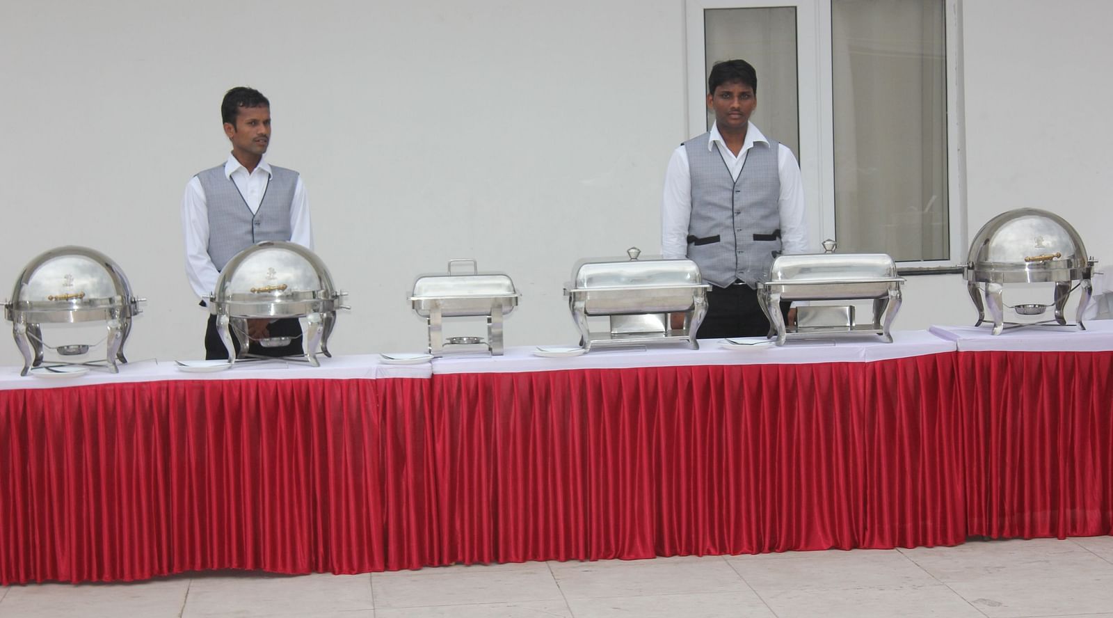 Two man standing behind a bufffet table at Swathi Hall at Hotel Green Apple