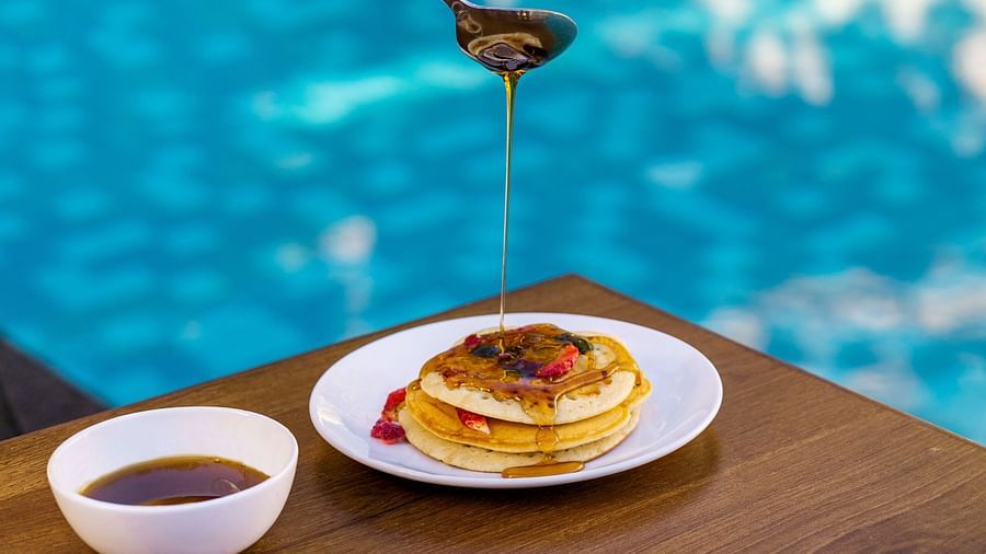 view of pancakes being drizzled with honey