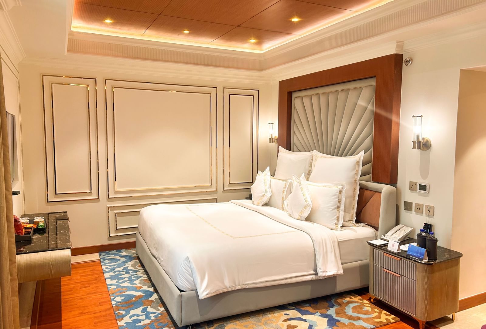 King-size bed in a room with accent wall panelling and warm lighting at Accord Metropolitan.