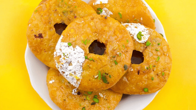 Mawa Kachori served on a plate, showcasing its golden, flaky exterior filled with rich mawa and garnished for an enticing presentation.
