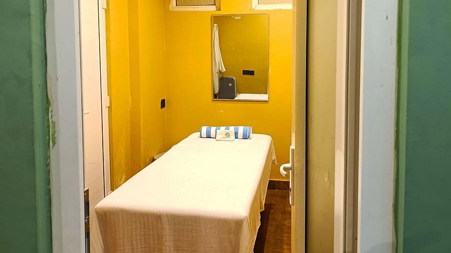Spa room at DLS Forest Vines Resort as seen from the entrance, with a neatly made massage bed.