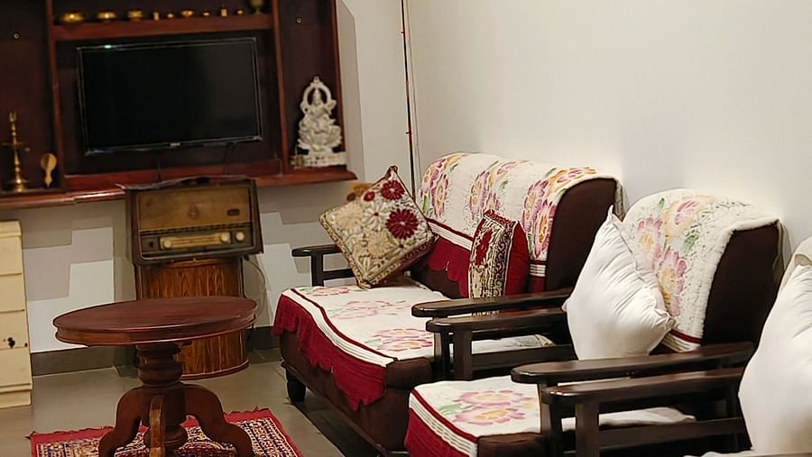 Three sofas kept in a row with a small tea table and a tv in the background in the Living Room at Ananda Holiday Home, Wayanad 9