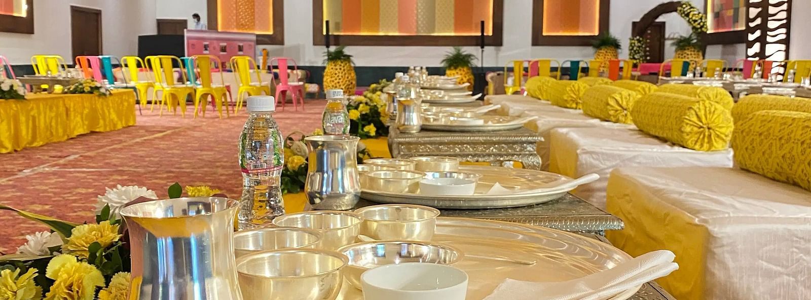 Hall with set tables, ceiling circles, and artwork.