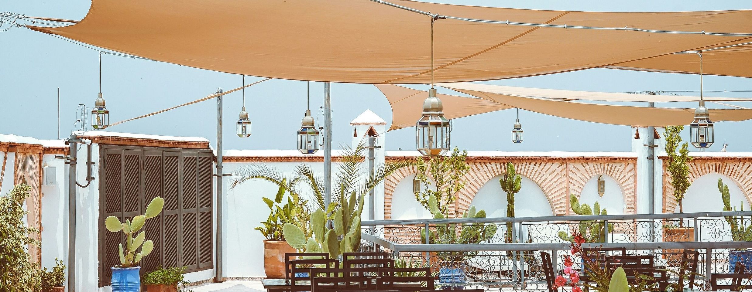 an overview of a rooftop restaurant with sun shade above the seating arrangements