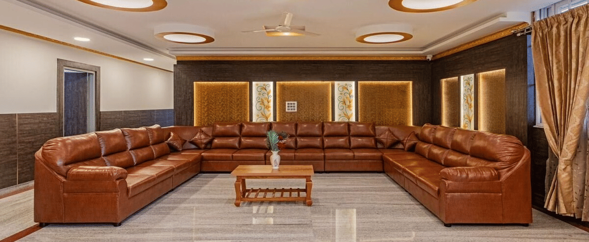 Luxurious lounge space with brown leather sofas, circular ceiling lights at Siri Ambari Resorts and Spa.