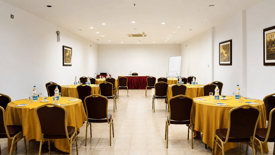 Frangi Pani Hall arranged in theatre-style seating with yellow table linens at Chariot Beach Resorts, ideal for meetings and conferences.