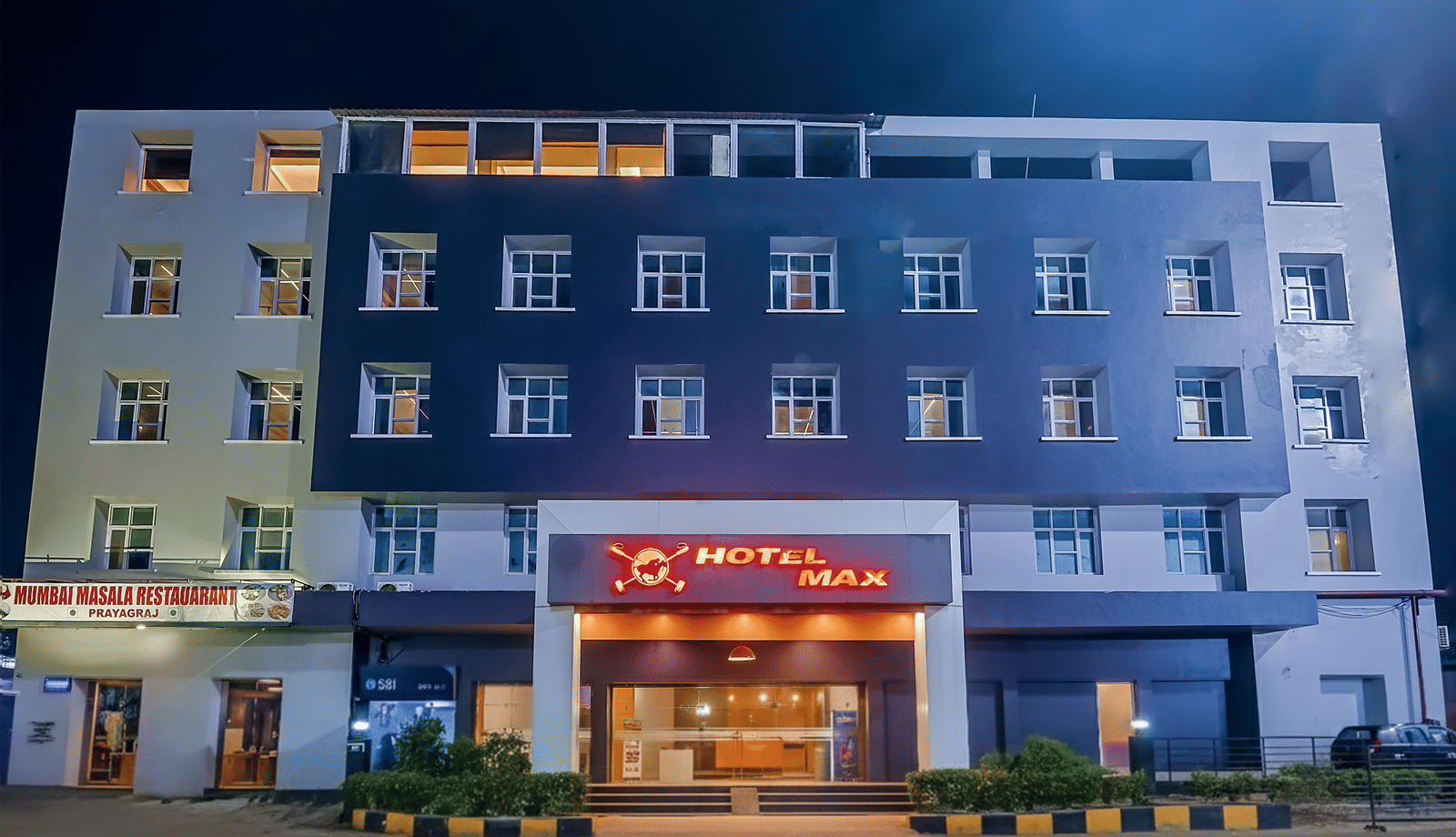 Exterior view of Max Hotel Prayagraj building with entrance at night.