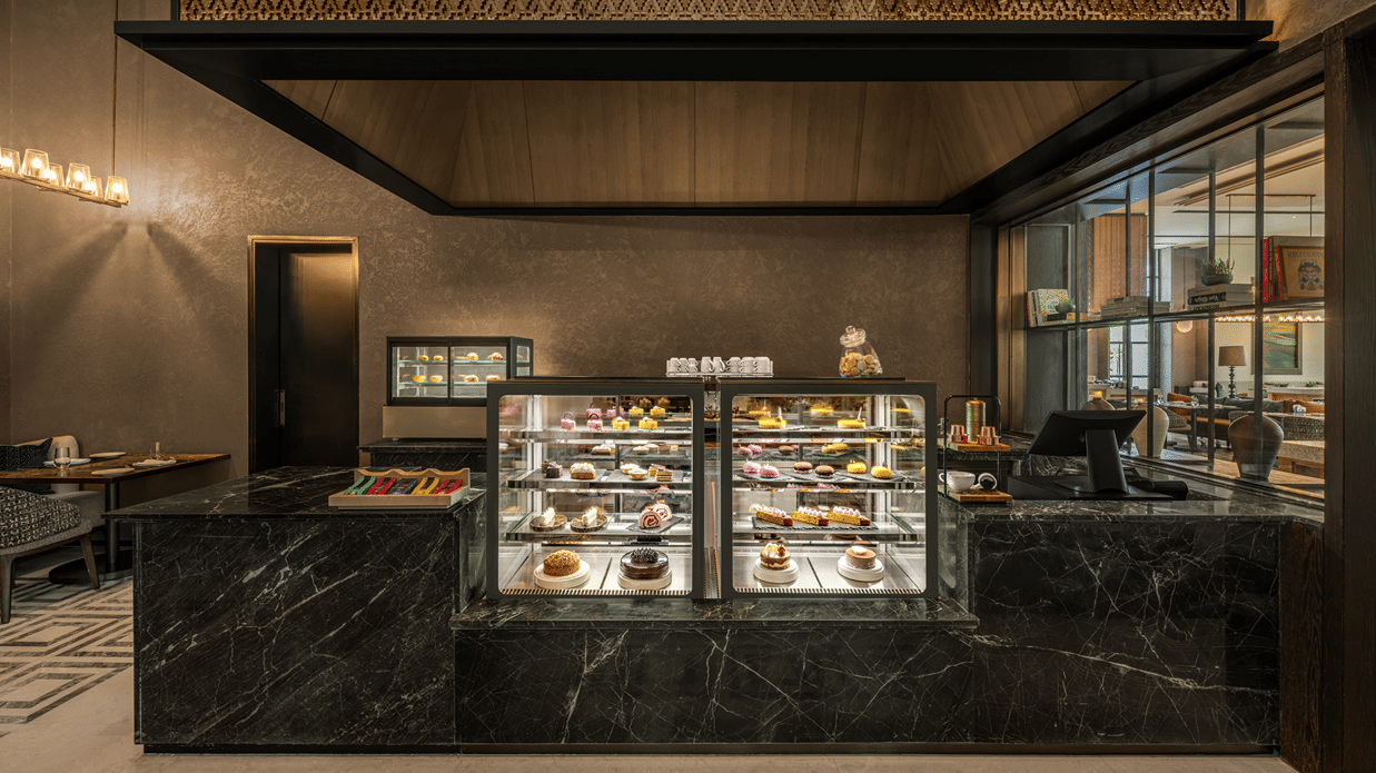 Krave counter with a glass display case and dark toned decor at The Residency Signature Madurai.