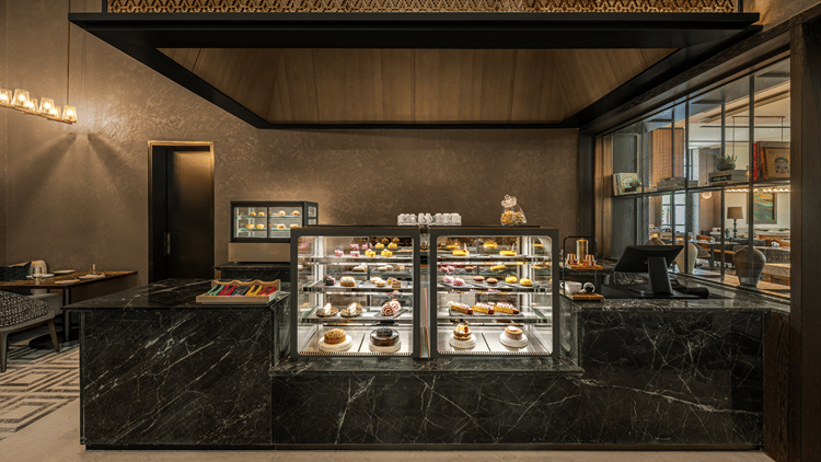 Krave counter with a glass display case and dark toned decor at The Residency Signature Madurai.
