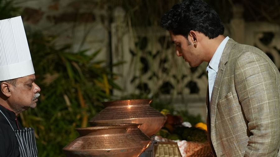 A guest converses with the chef while exploring a buffet of Indian cuisine in copper pots - Khas Bagh, Jaipur.