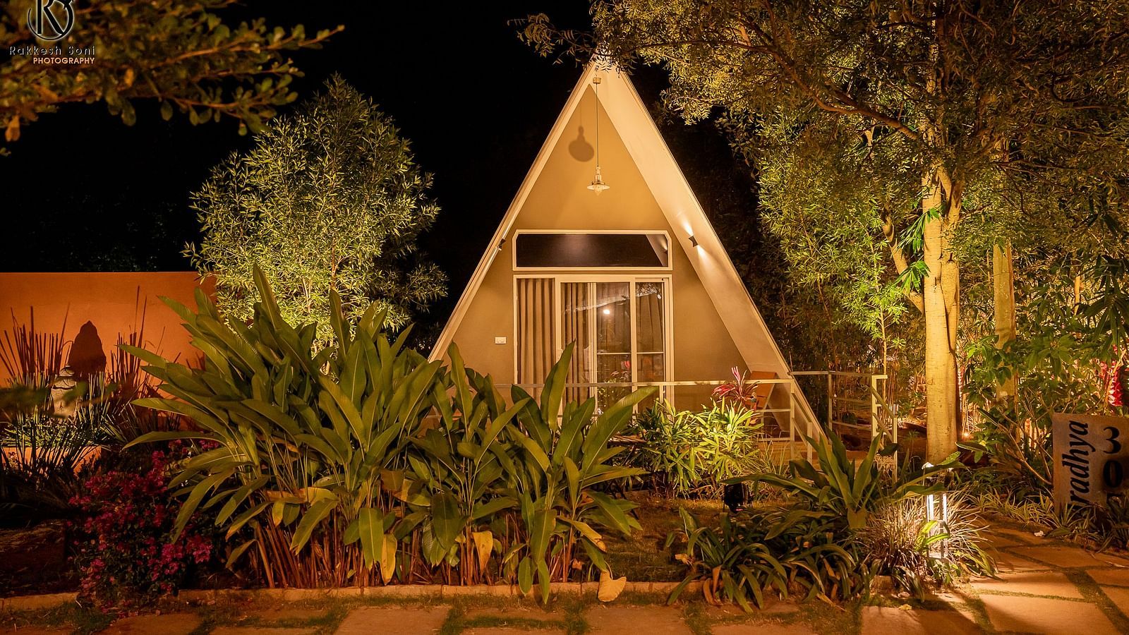 A facade image of the Aradhya cottage with bright lighting and greenery around - Trance Veechika Resort