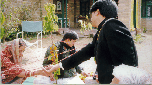 An image of a couple performing their Kumaon Wedding rituals in front of the Old Bungalow building - Ramgarh Bungalows, Nainital.
