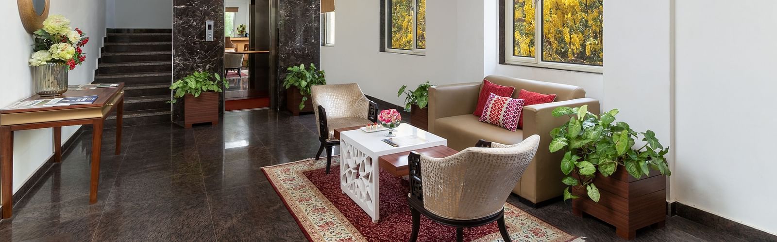 A spacious hotel lobby with comfortable seating, elegant decor, and plenty of natural light | Inde Hotel Cyber City