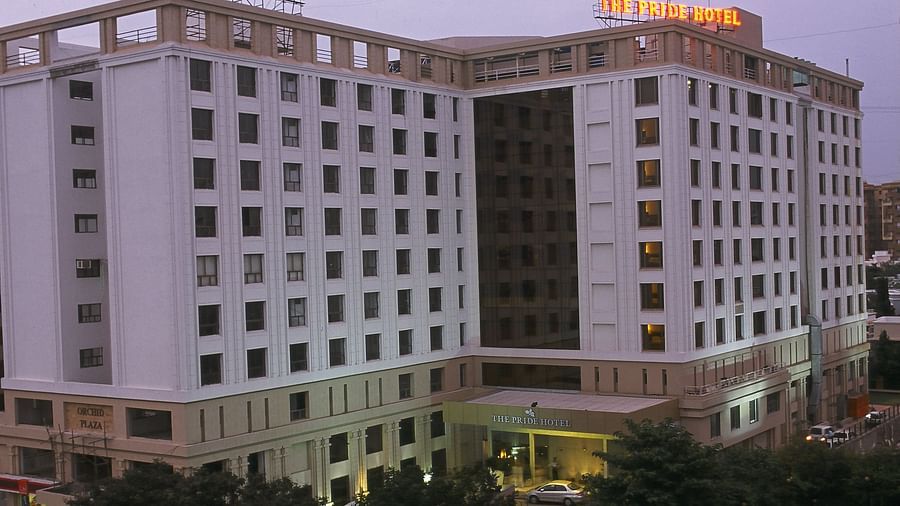 A facade image of Pride Elite Daman featuring multi storey building surrounded by trees