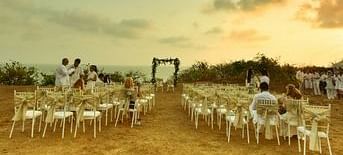 Neatly arranged chairs in an outdoor wedding venue at Fort Tiracol with an aisle leading up to an altar.