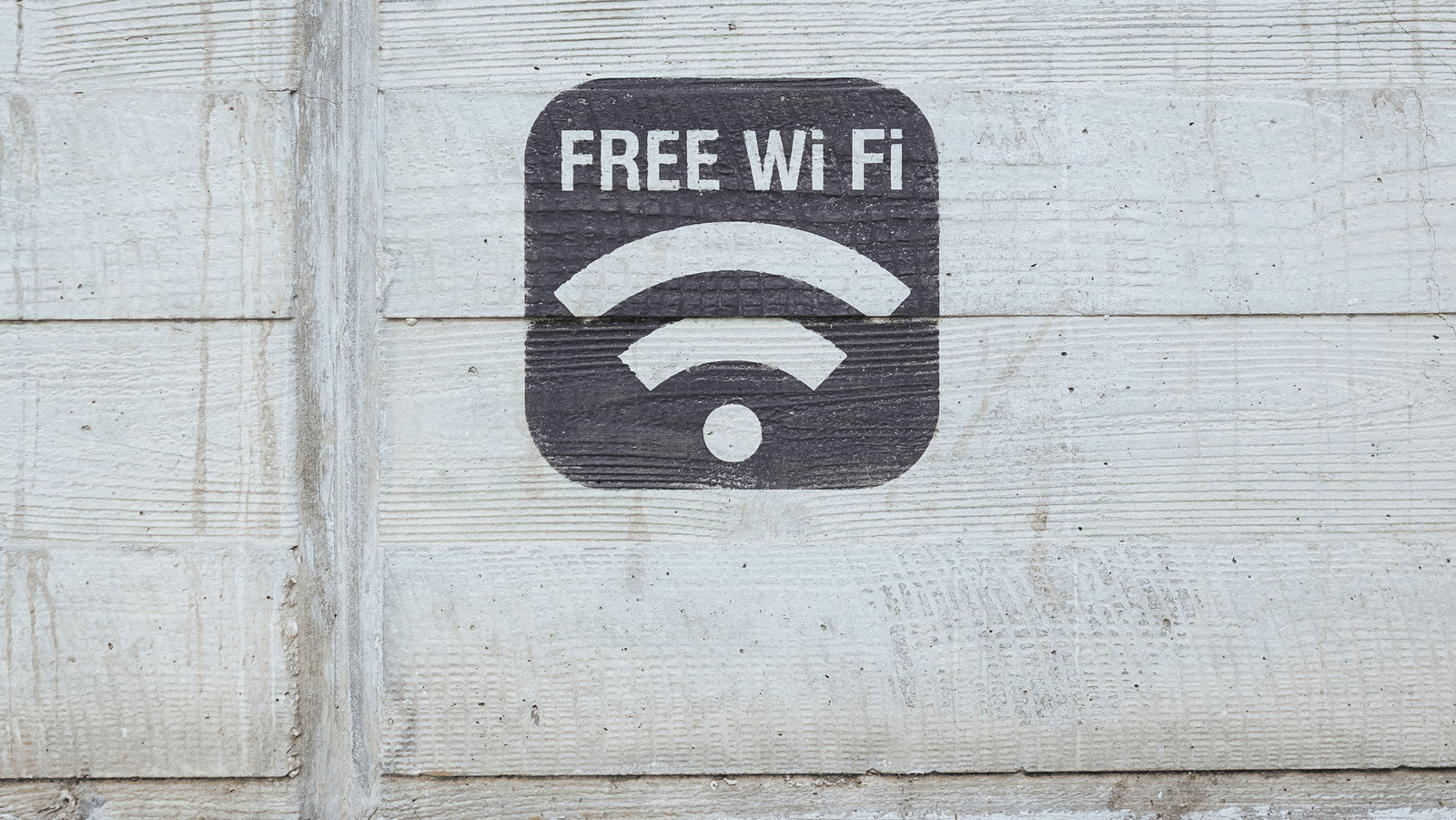 Free Wi Fi sign painted on a concrete wall indicating complimentary internet access.