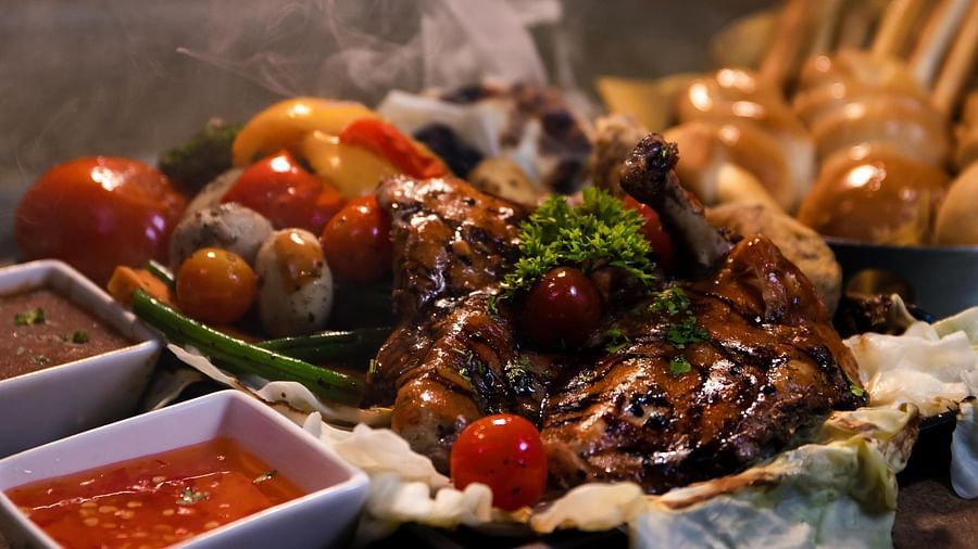 Barbequed chicken served alongside some vegetables