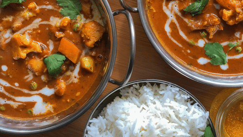 A spread of Indian cuisine with bowls of rice and curry. 