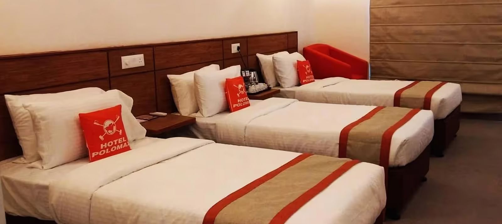 View of a Hotel room with three beds arranged, bedding, and a modern design in Max Club Room - Max Hotel Prayagraj.