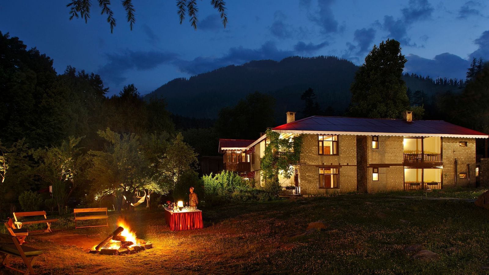 Bonfire in the outdoor with facade of Bedzzz Xclusiv Baikunth in the background