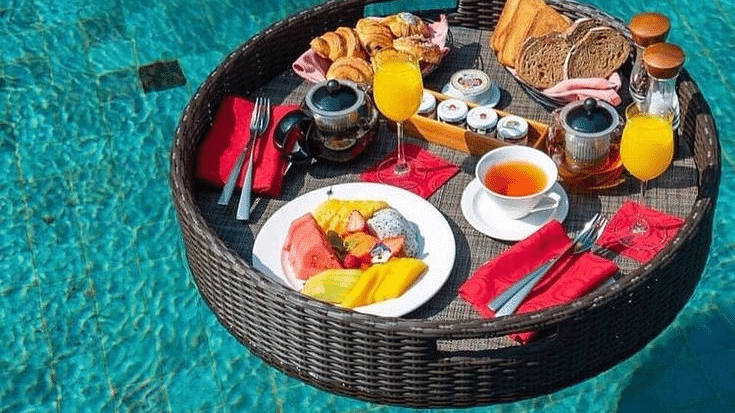 A tray floating on a water body with a variety of food placed on it at Valley by Grassfield.