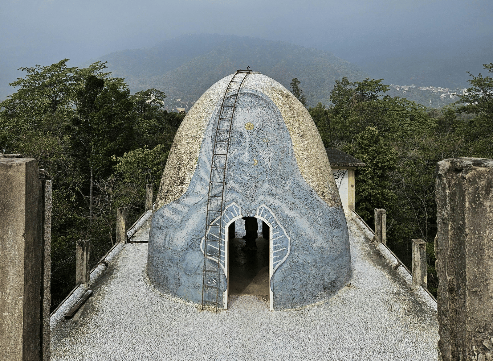 Close-up of a white structure set against a cloudy mountain backdrop.