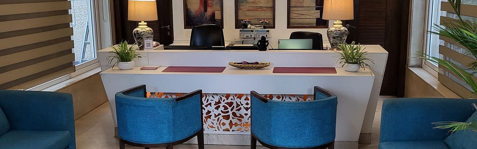 An image of a reception lobby featuring sofas, chairs, reception desk, and lights hanging from the ceiling - Inde Hotel Signature Tower Gurgaon