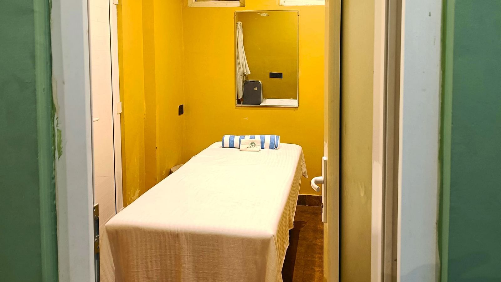 Spa room at DLS Forest Vines Resort as seen from the entrance, with a neatly made massage bed.
