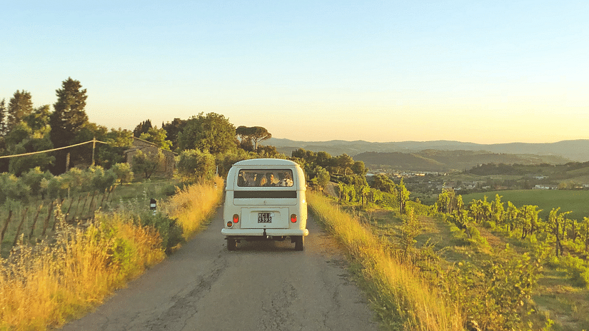 A truck on the road surrounded by greenery and clear skies