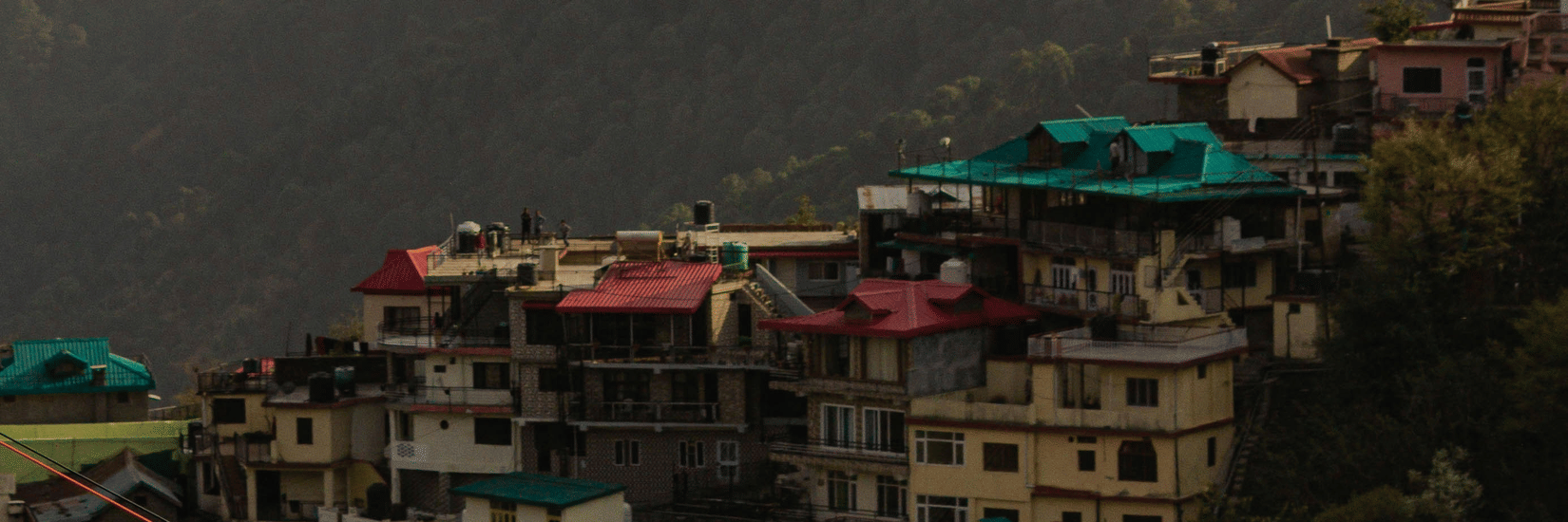 Hillside view of Kasauli with clustered homes overlooking the scenic Shivalik mountains.