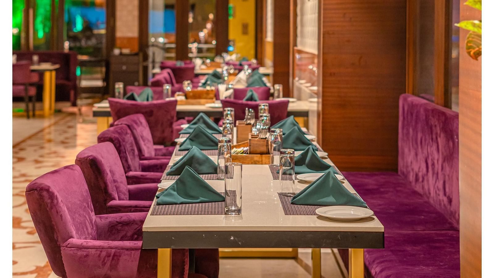 Cushioned chairs and a table set with exquisite culinary offerings for guests at Courtyard Fine Dine, Crescent Spa & Resort, Indore